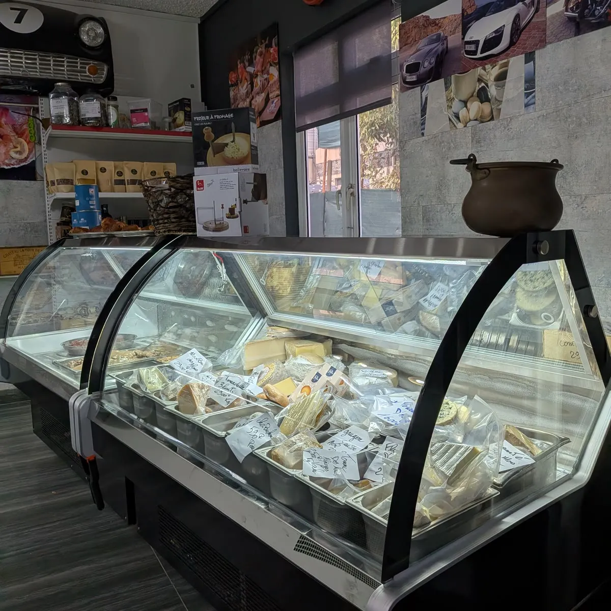 Les deux nouvelles vitrines réfrigérées, garnies de fromages à la coupe étiquetés à la main